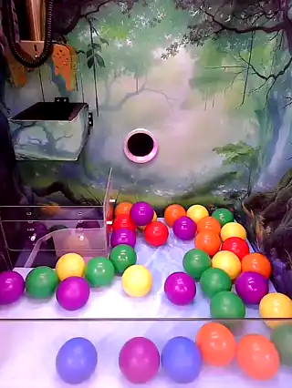Claw descending into the ball pit on the Foggier Forest machine
