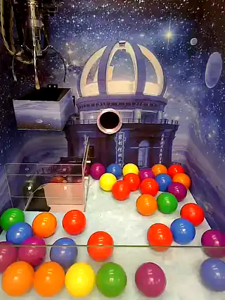 Claw working in front of the Starry Lighthouse machine's dome artwork